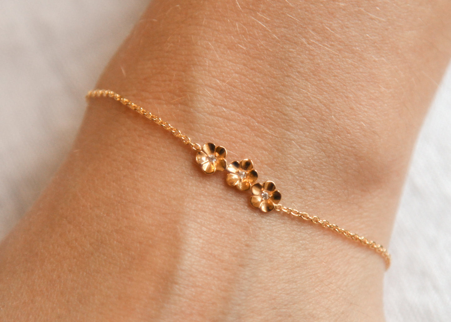 Bracelet 3 fleurs plaqué or serti de 3 petites pierres brillantes