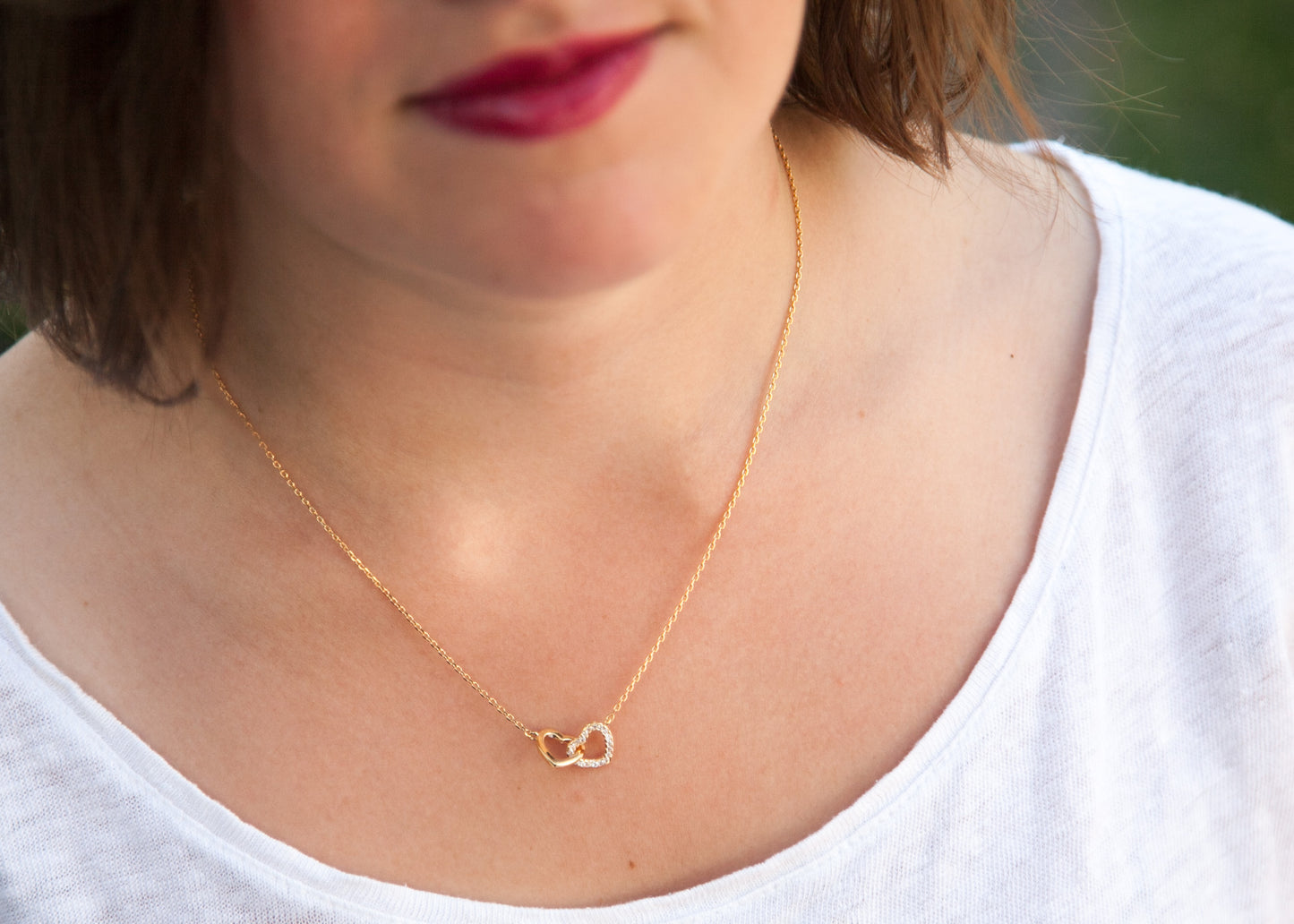 Collier coeurs entrelacés serti de zircons plaqué or