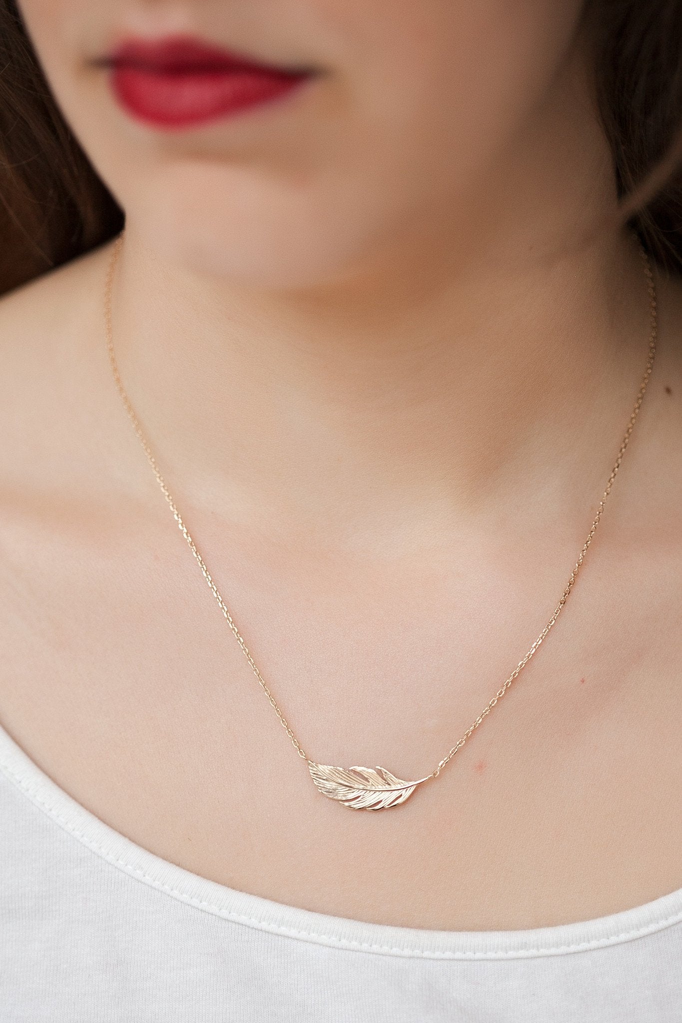 Collier avec plume d'oiseau plaqué or