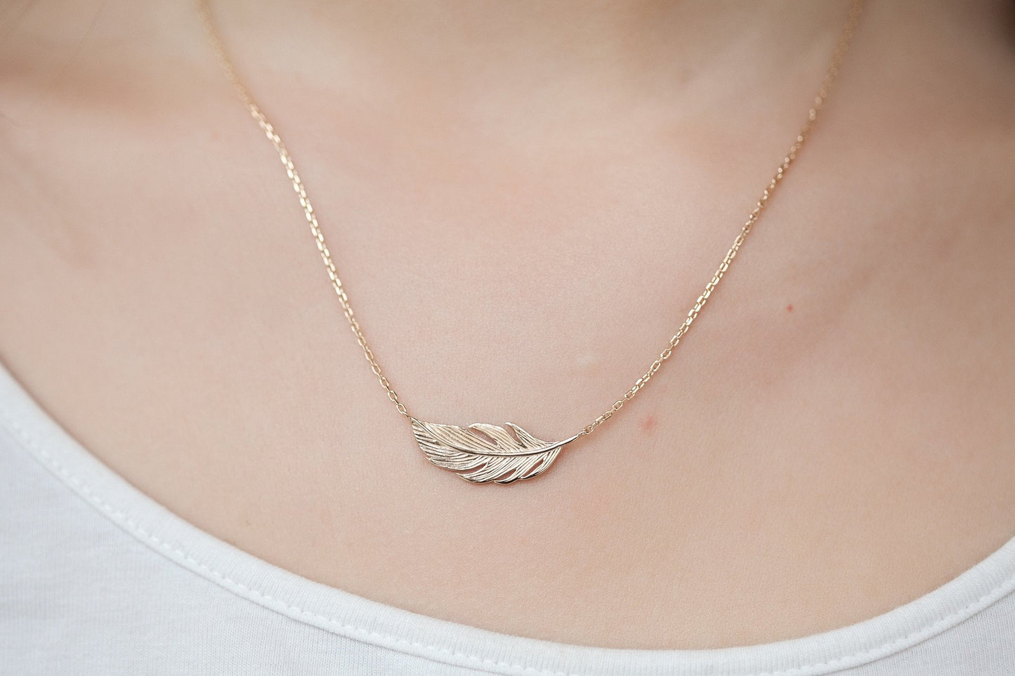 Collier avec plume d'oiseau plaqué or